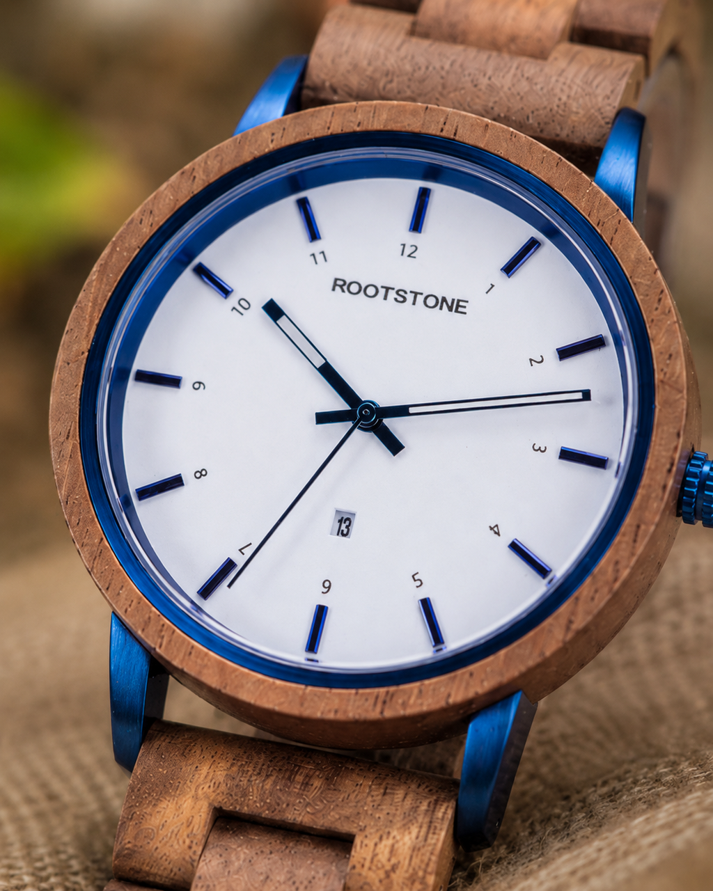 Detailansicht der Rootstone BLÅSKOG Herrenuhr mit Holzgehäuse, blauer Lünette, blauen Bandanstößen und weißem Zifferblatt