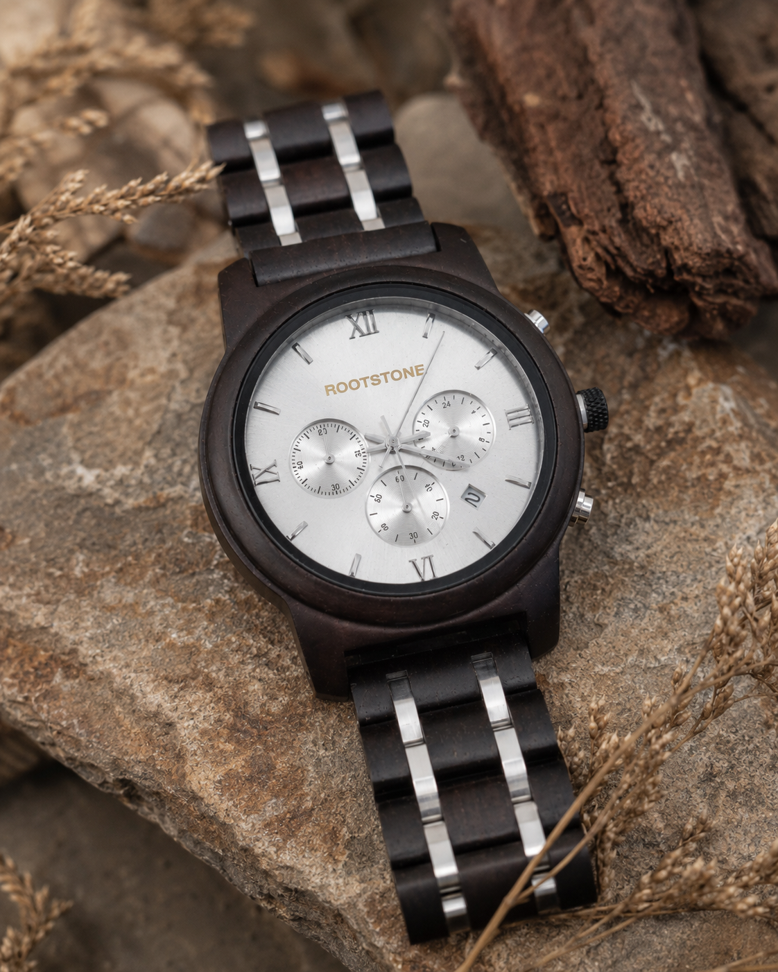 Rootstone SØLVSKOG Herrenuhr aus dunklem Holz und Metall mit silbernem Chronographen-Zifferblatt auf Naturstein